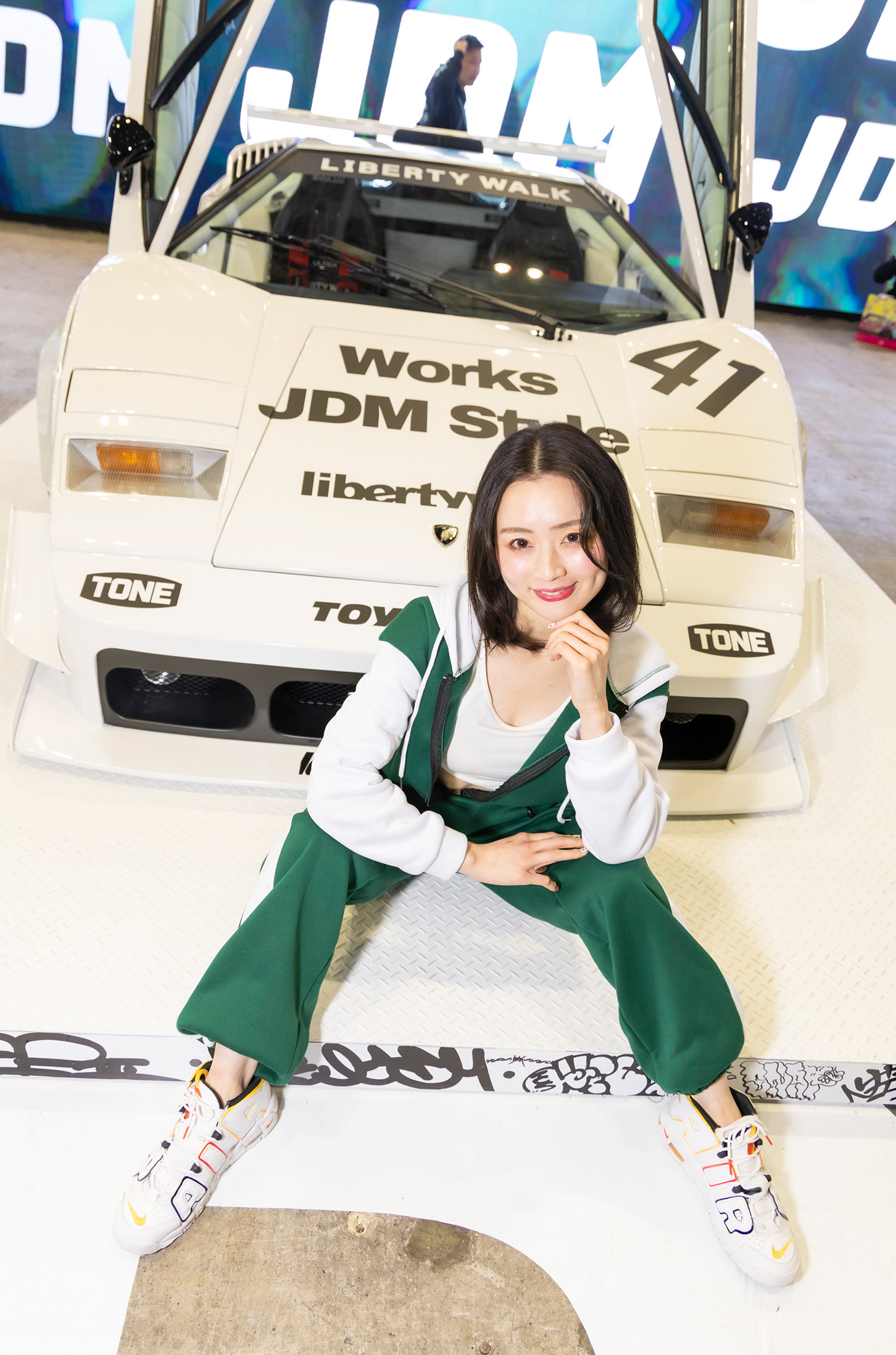ランボルギーニ・カウンタックのカスタムカーのフロントの前でポーズする美女