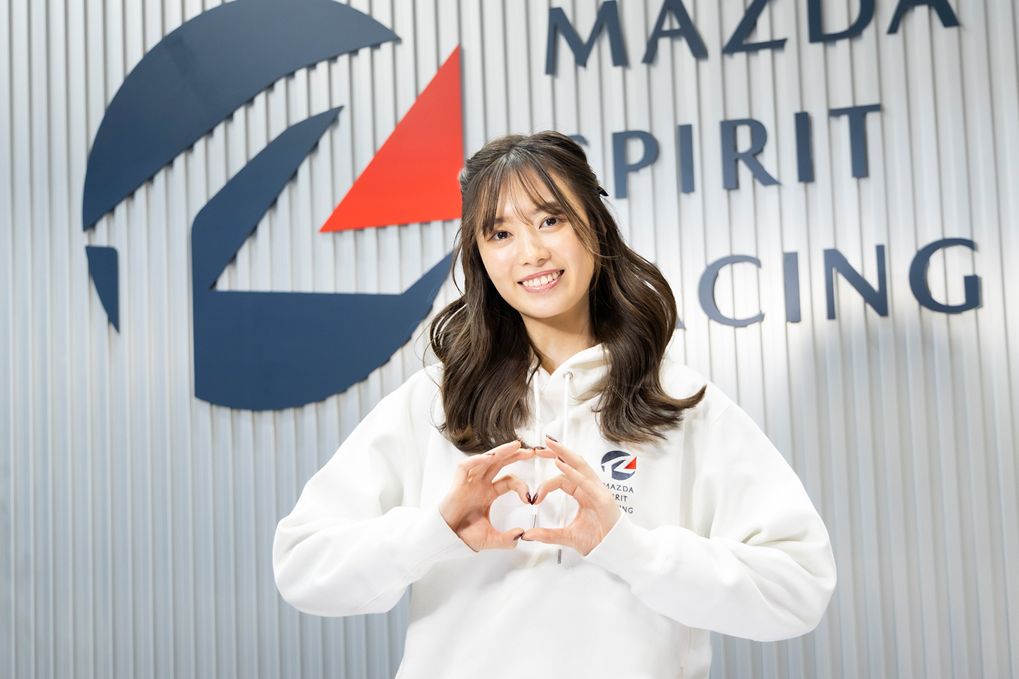 満面の笑みでマツダポーズをしてくれる美女