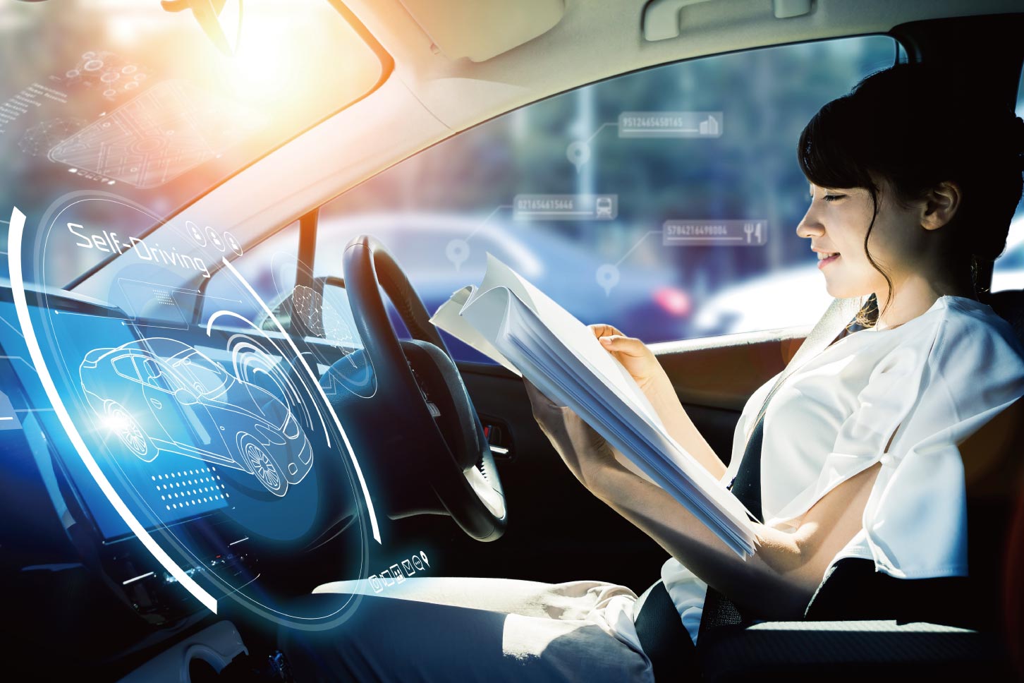 自動運転中に書類に目を通す女性。(c)metamorworks – stock.adobe.com