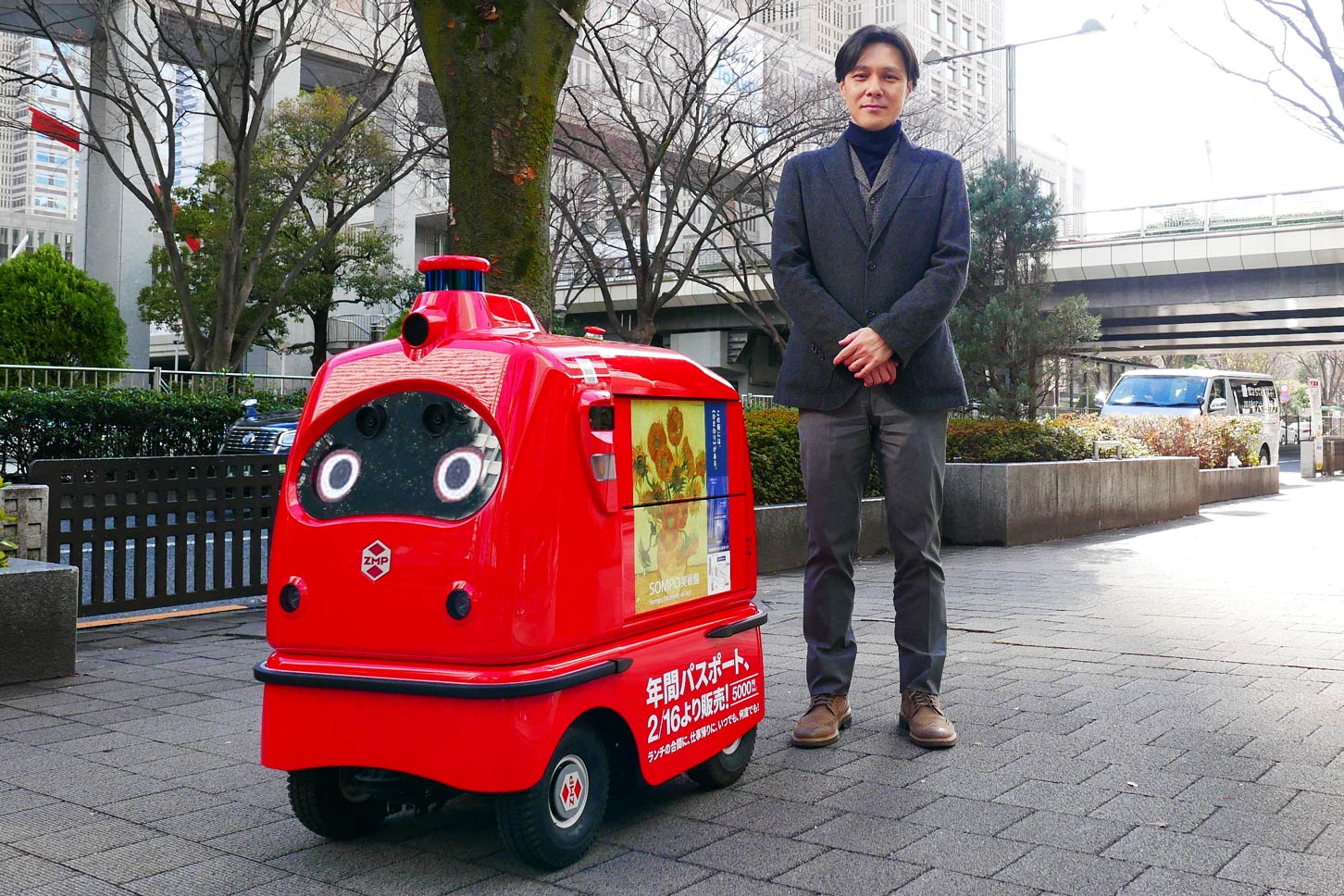 無人宅配ロボDeliRo(デリロ)と、ロボット配達の実証実験を管轄しているNTT Comの田代さん。デリロにはRakuRo(ラクロ)という人を乗せられるモビリティと、PATORO(パトロ)という警備ロボの兄弟機が存在する。
