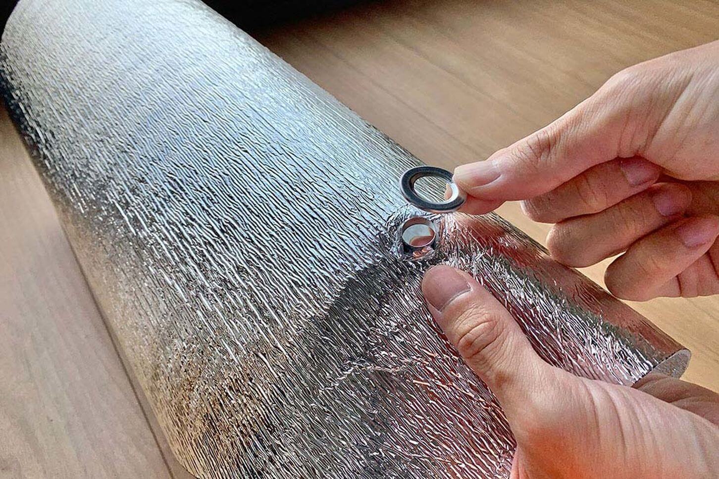 100均のハトメ固定用工具を使って、穴にハトメを取り付ける